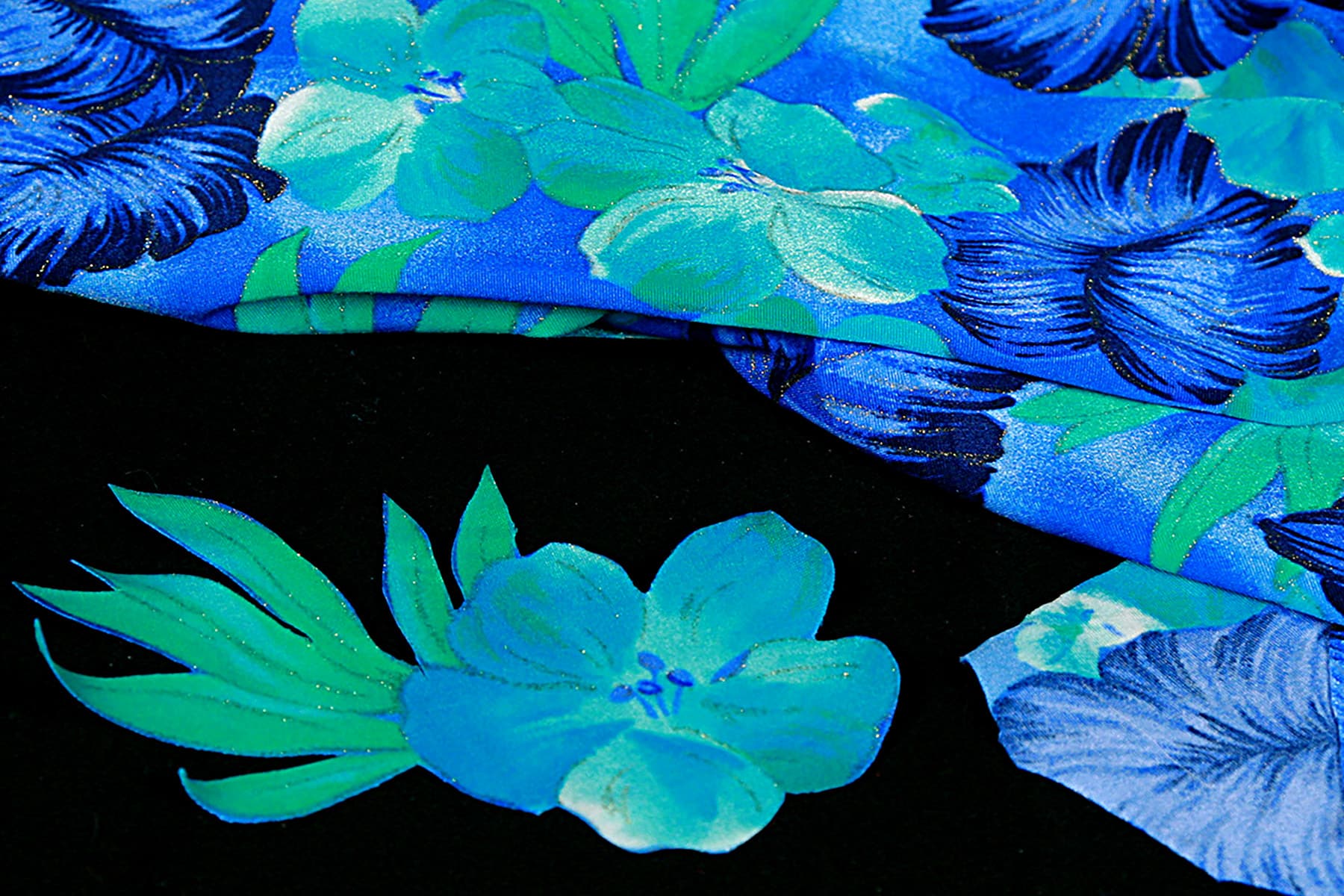 A piece of blue floral fabric with a flower cut out of it.