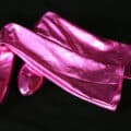 A pair of shiny purple spandex boot covers on a black background.