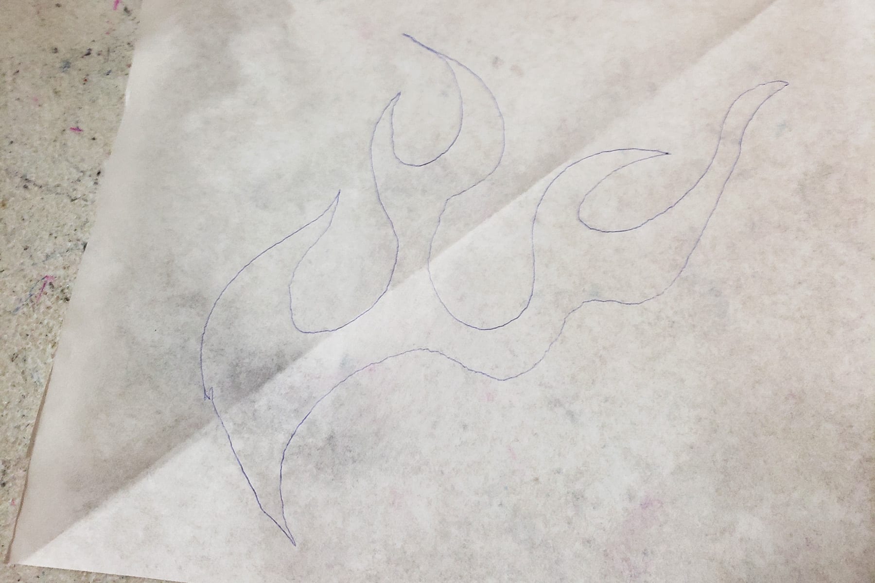 A piece of medical exam table paper with hot rod flames drawn on it in pen. This is the applique pattern.