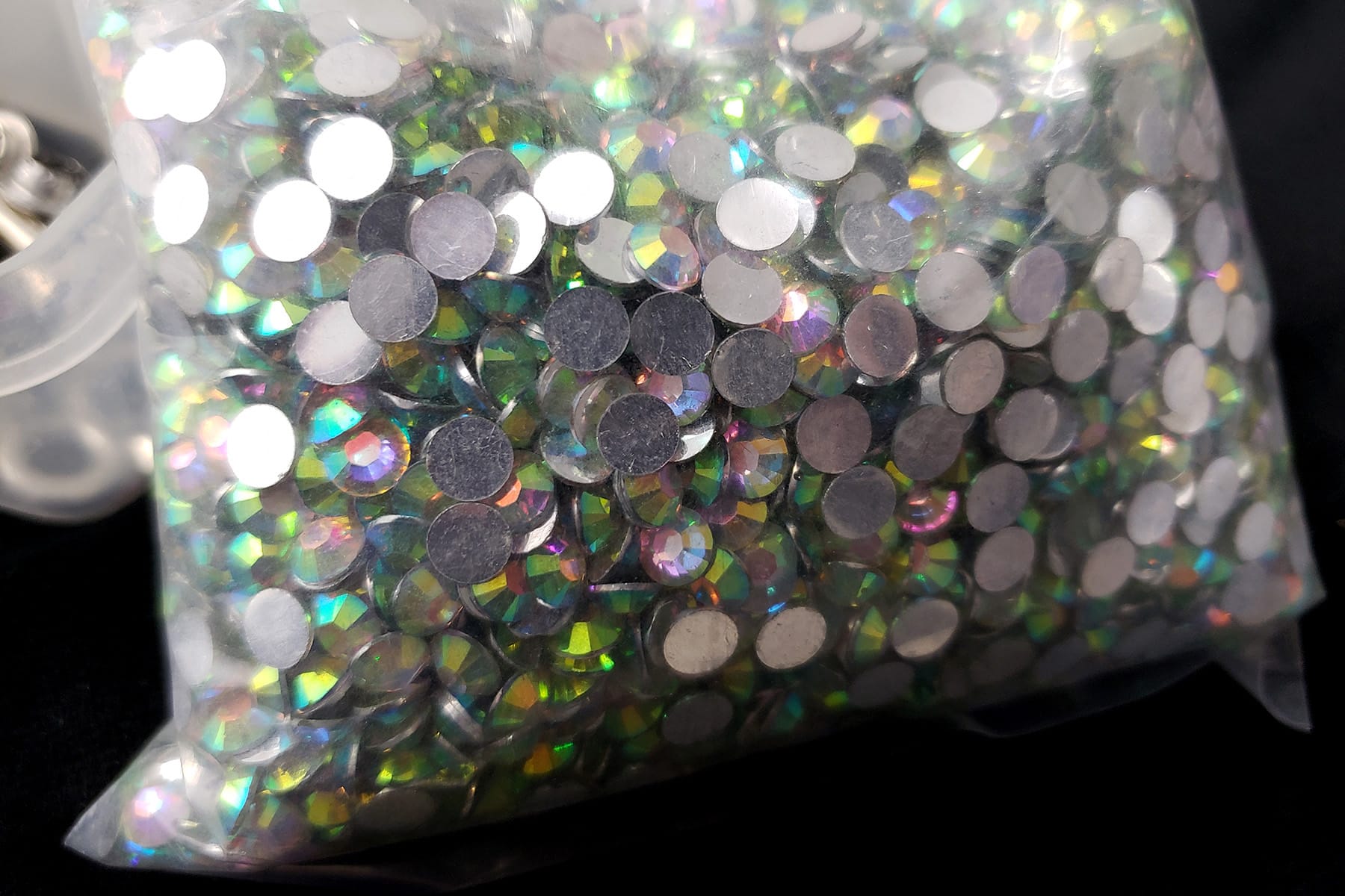 A close up view of a bag of green-tinged rhinestones.
