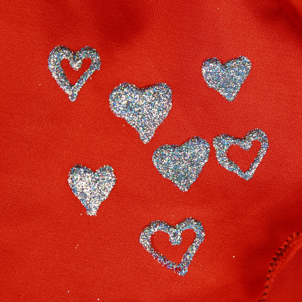 Silver holographic glitter hearts on orange spandex.