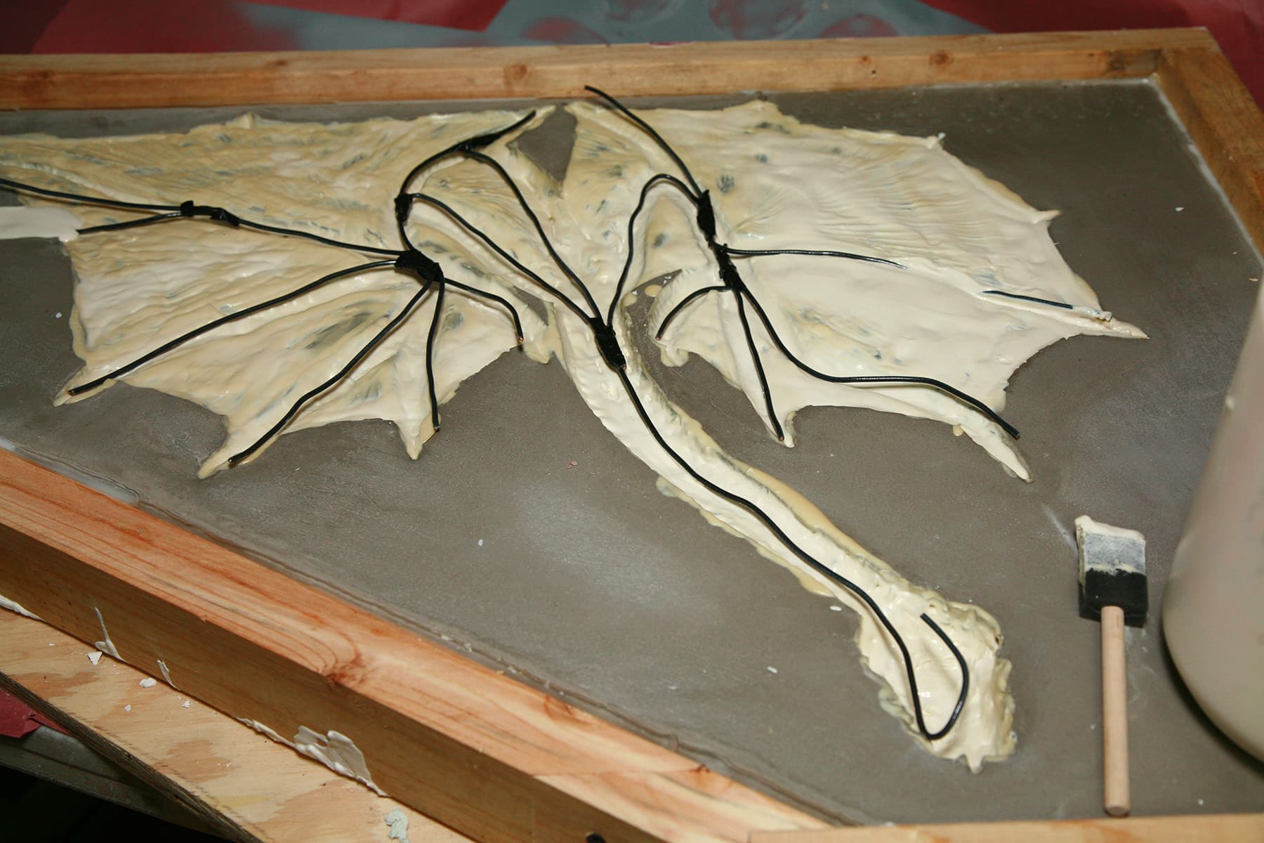 A thin layer of latex is in the mold, and the wire skeleton has been placed on it.