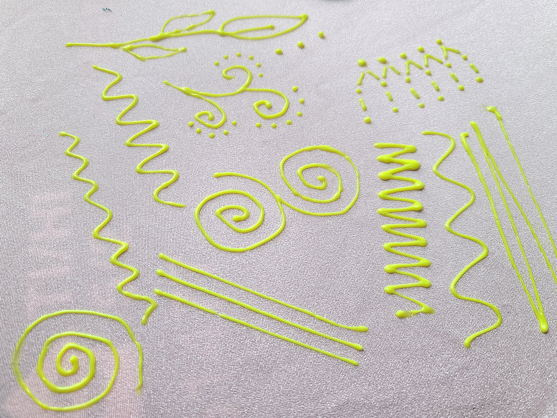 Neon yellow stretch fabric paint designs on a light pink spandex background.