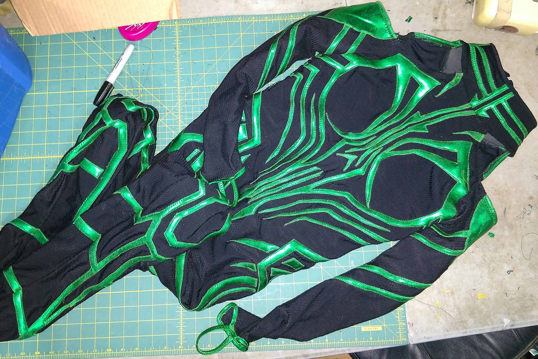 A sewn together Hela costume, laid out on a green work surface.