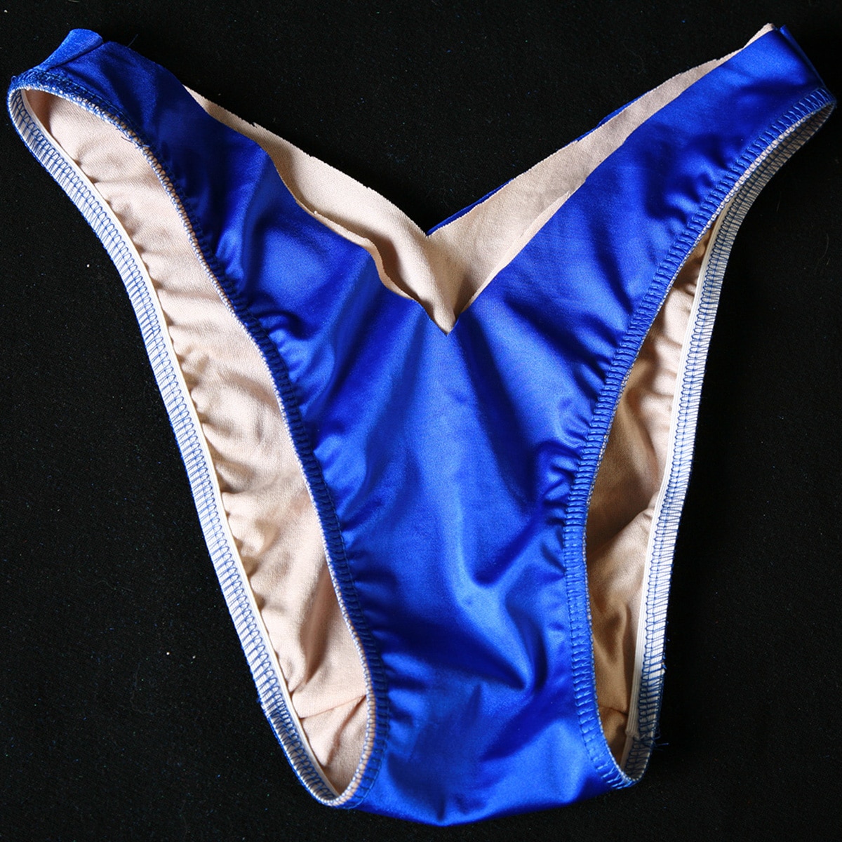 Blue v cut bikini bottoms with elastic applied to the legs.