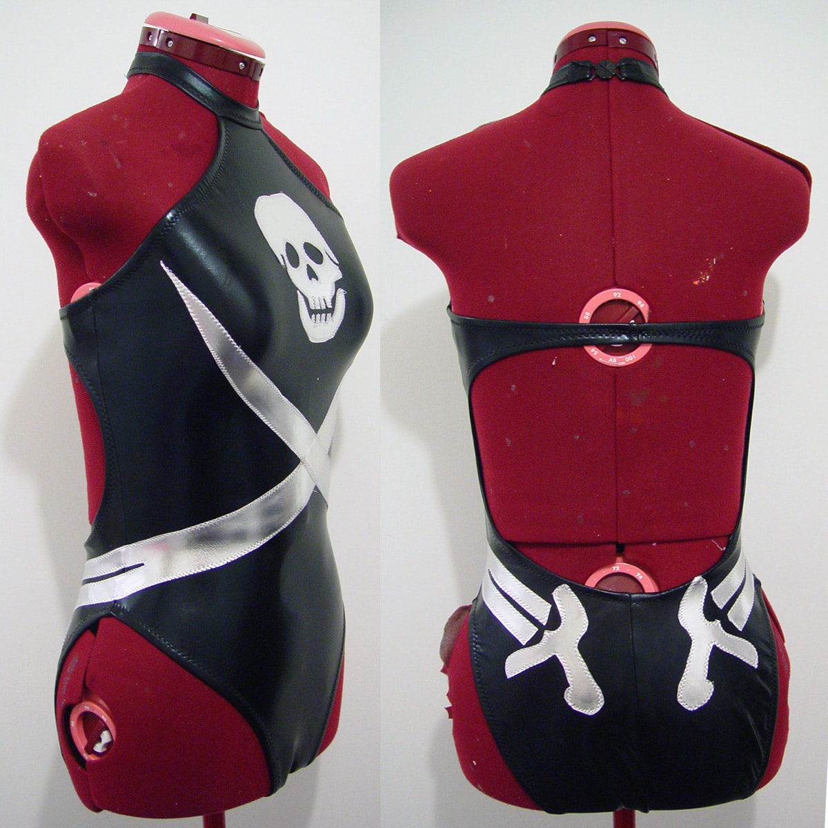 Front and back views of a black swimsuit with pirate flag design. It has a choker halter style.