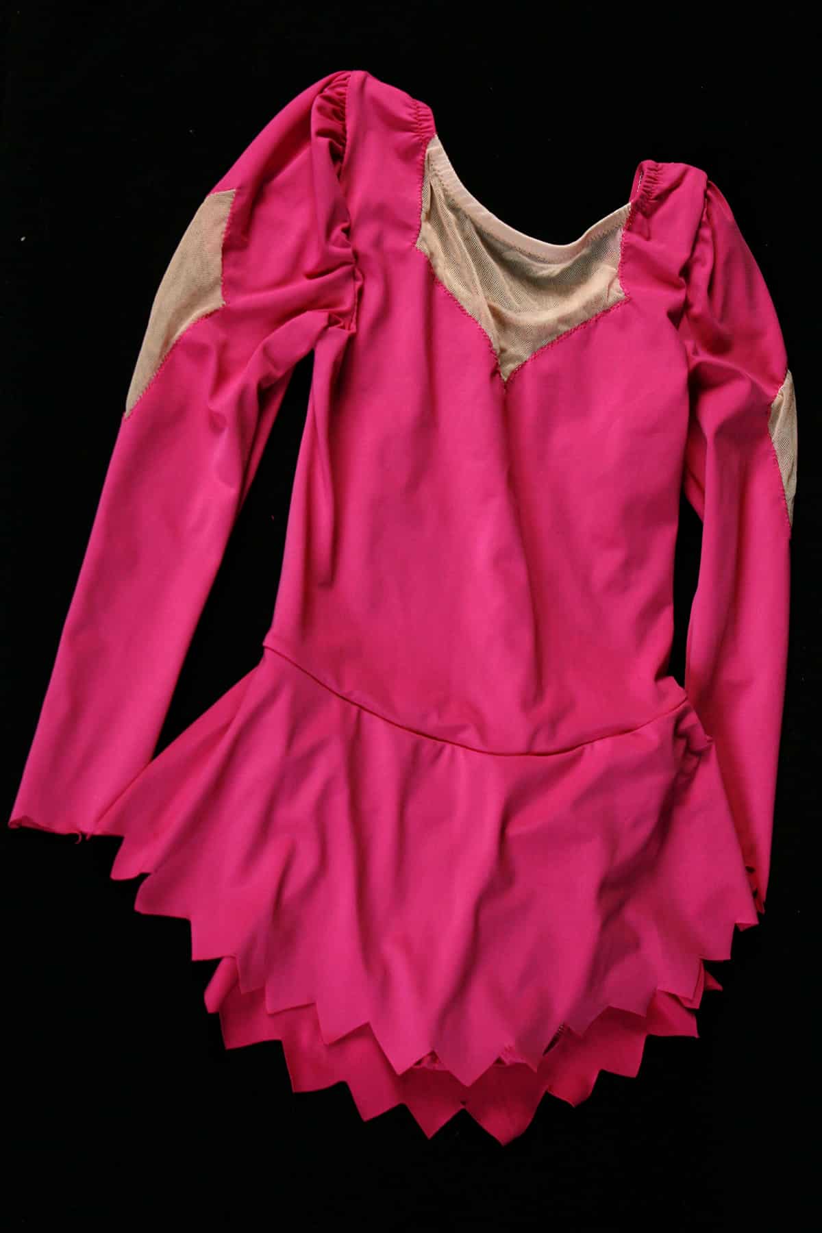 A hot pink skating dress with a jagged cut hem.