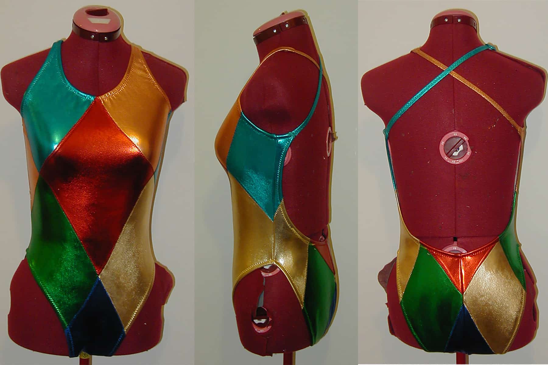 Front, back, and side views of a Harlequin stype synchro swim suit, in blue, orange, red, green, and gold.