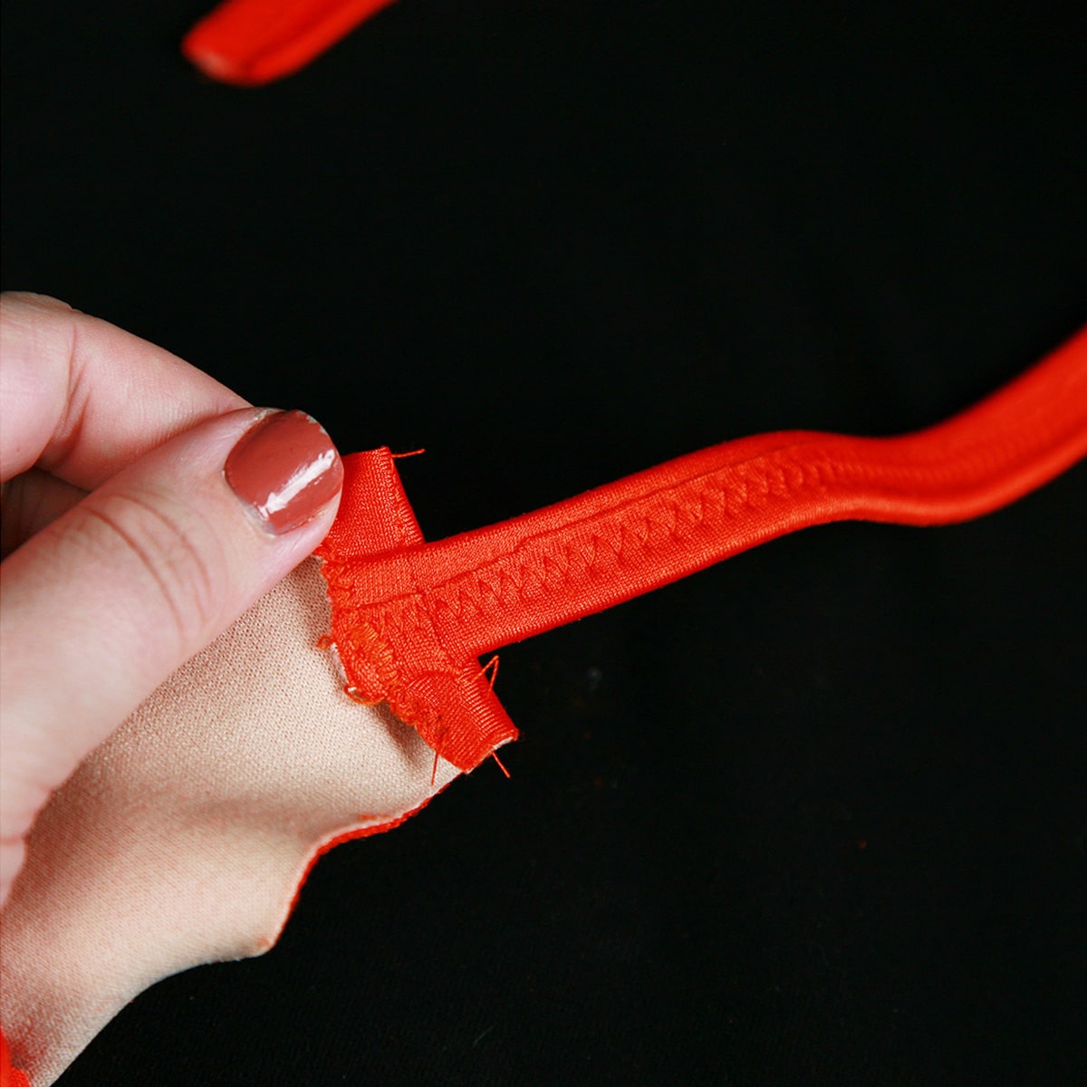 An elastic strap sewn to the body of a suit.