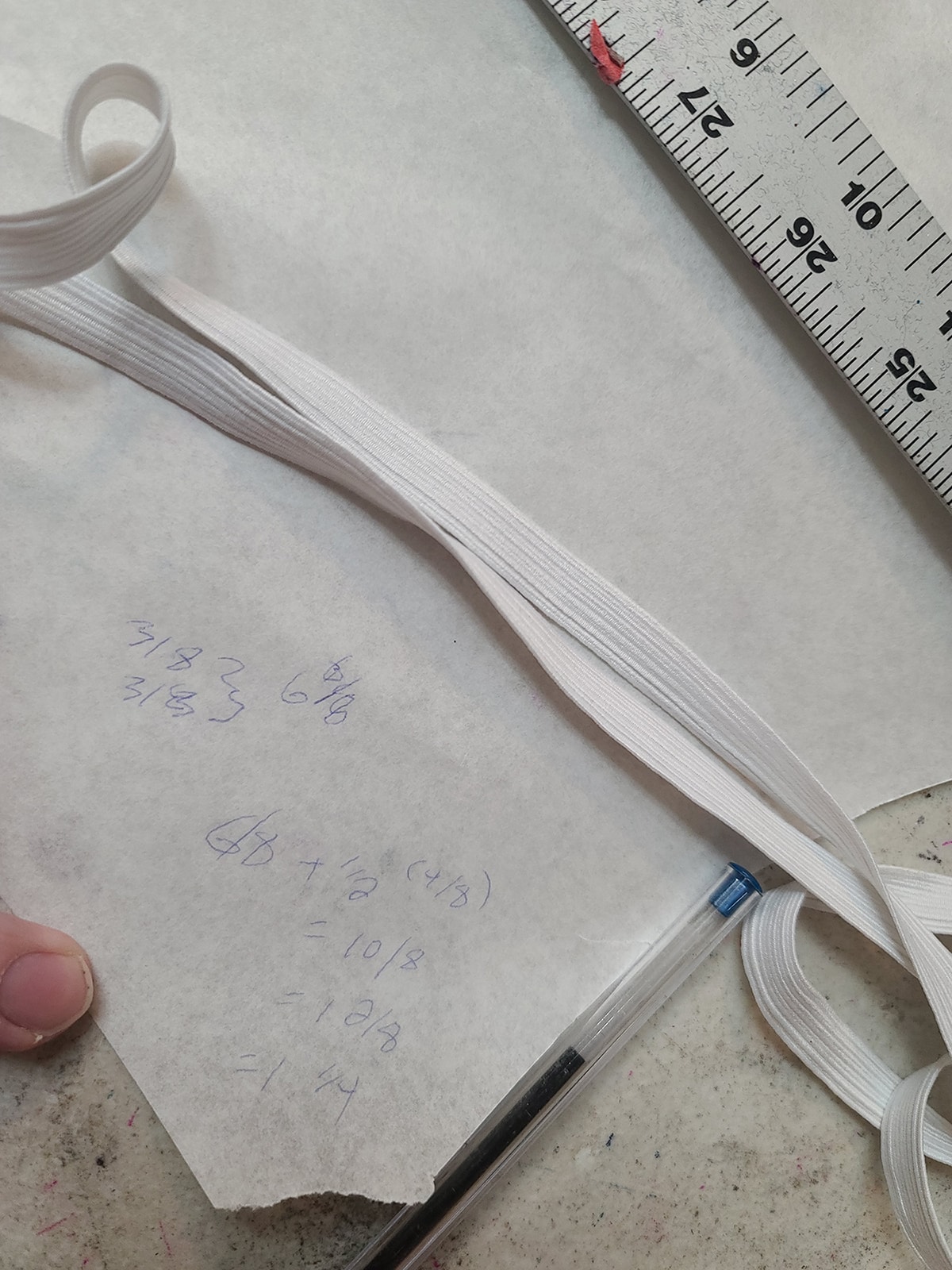 A piece of elastic on a paper with a ruler.