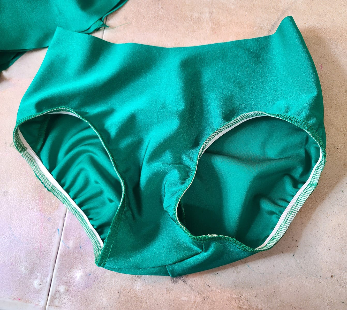 A green swimsuit bottom with elastic sewn into the leg holes.