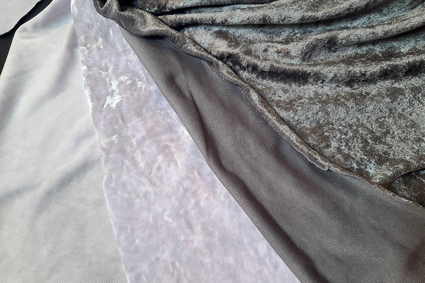 a piece of white crushed stretch velvet next to a piece of grey panne velvet.