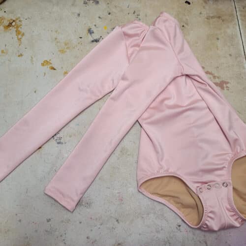 A pink bodysuit with long sleeves.