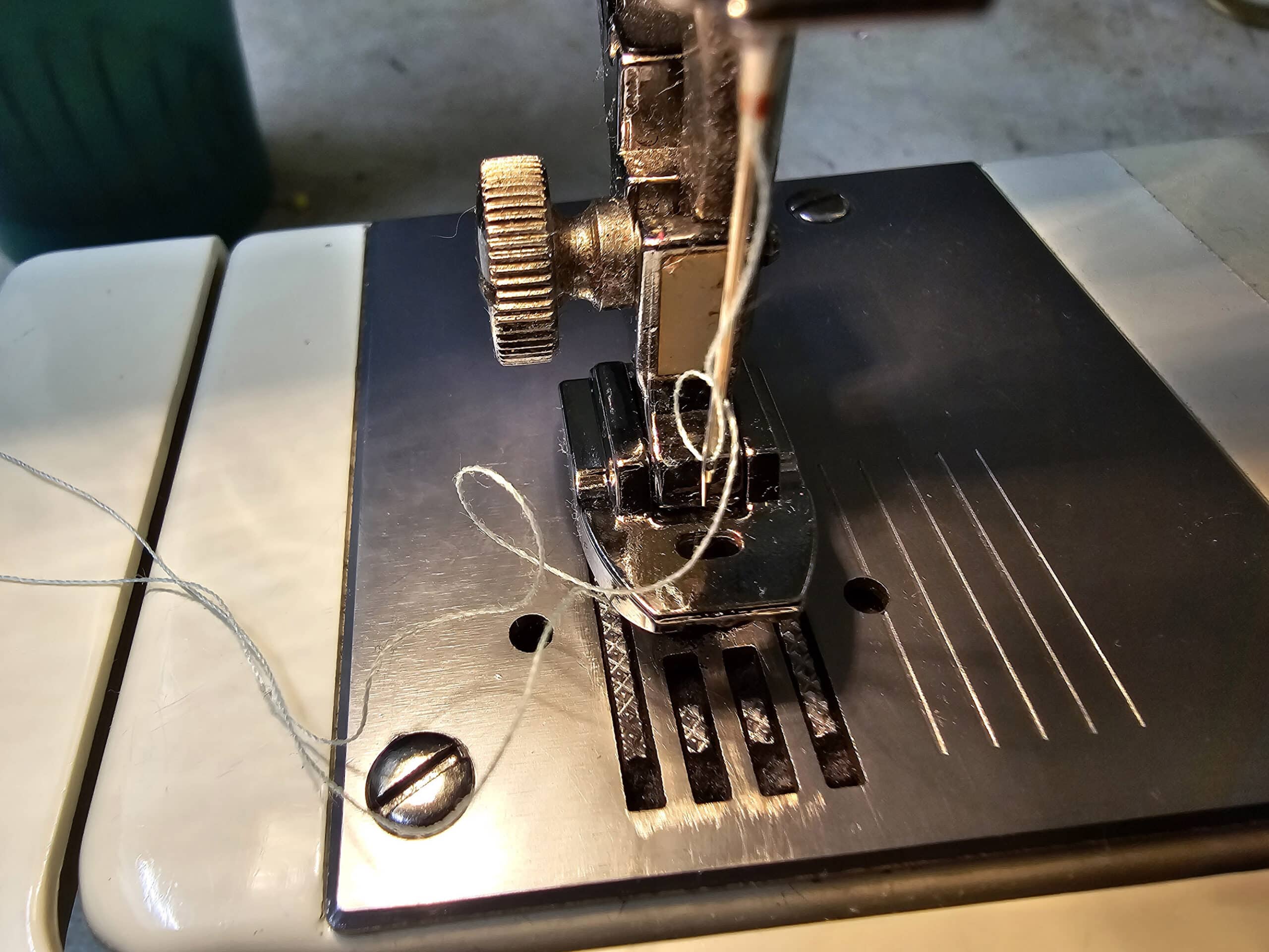 A close up view of a sewing machine set up with a zipper foot.