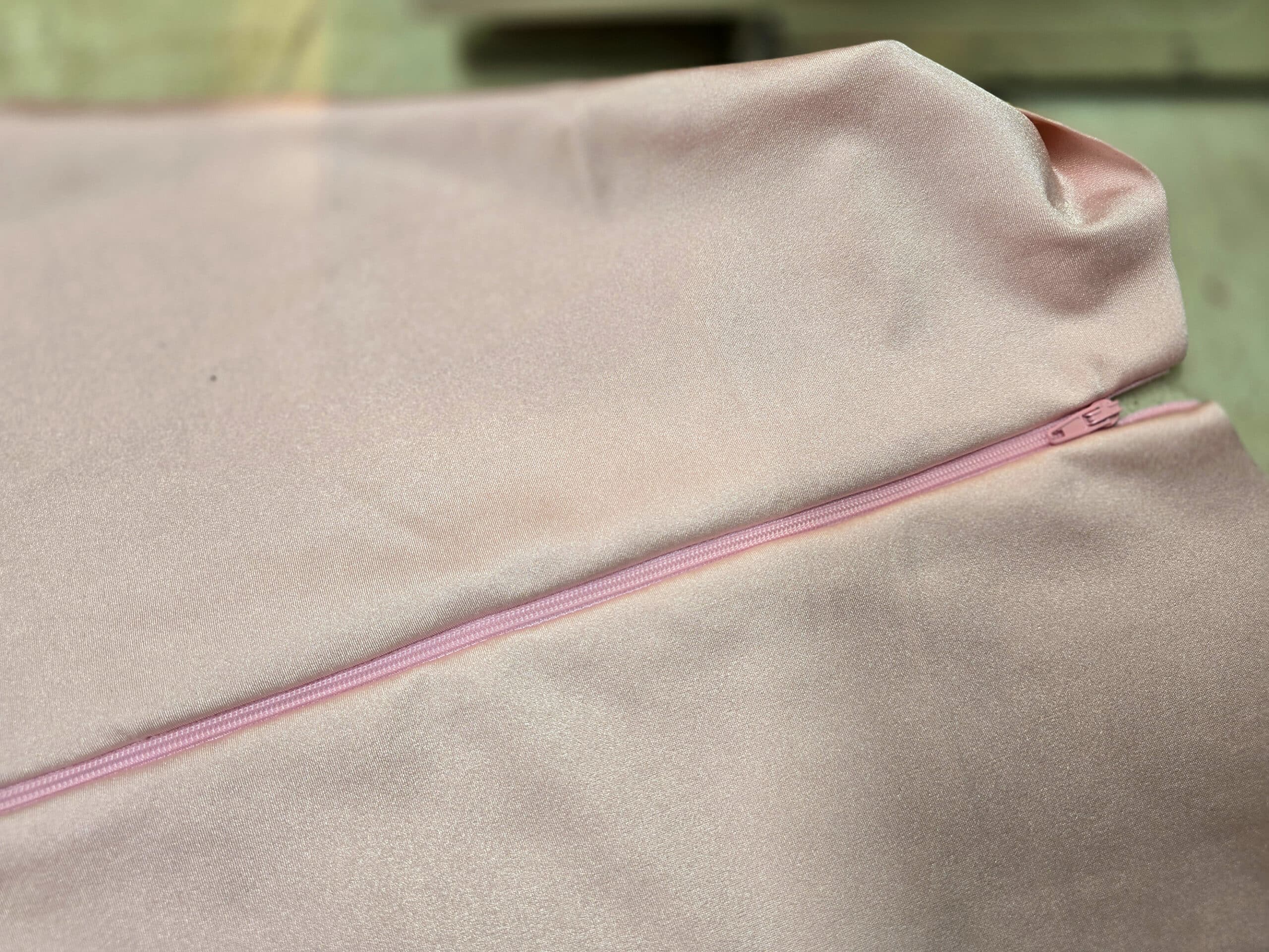 A pink regular zipper sewn into pink spandex.